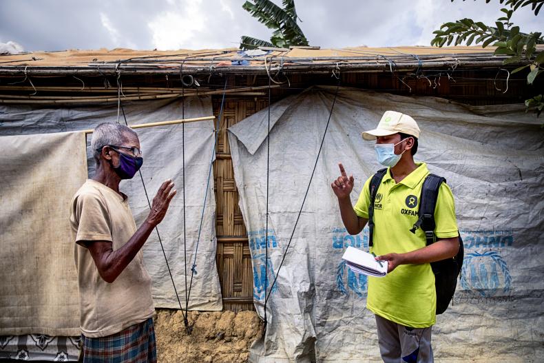 Oxfam volunteer Zahid Hossain (20) is talking to Abdul Malek* (80) about precaution elderly has to take during Covid19 outbreak in the camp. Cox's Bazar, Rohingya refugee camp. Bangladesh.